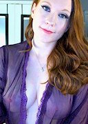 Busty redhead is naked on cam