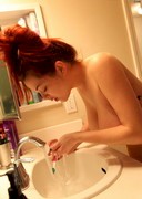 Topless babe brushing teeth
