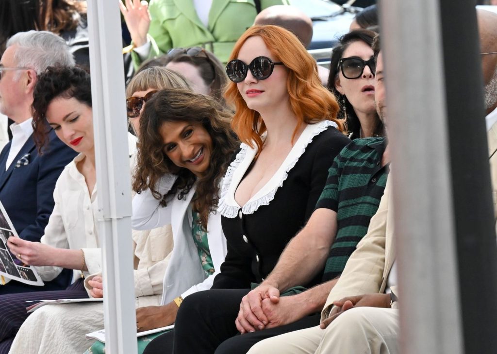 Beautiful redhead wearing sun glasses while sitting down at an event