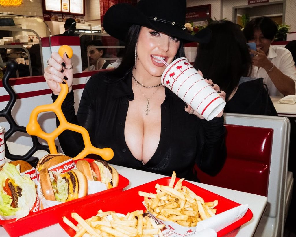 Big boob cowgirl sucking on a straw at a burger restaurant