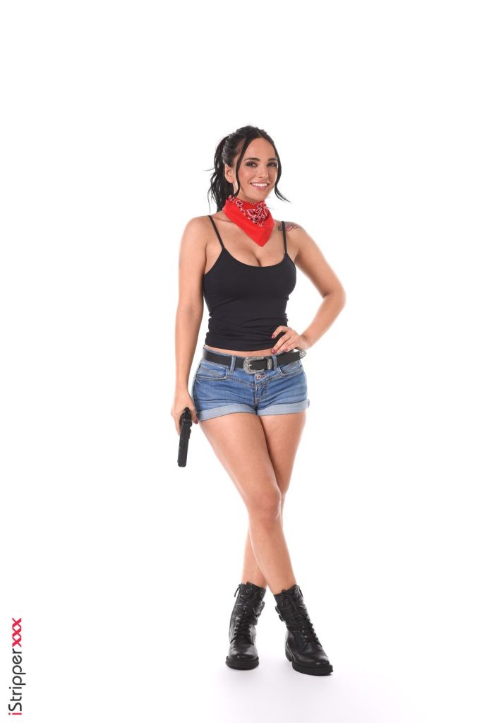 Sexy Latina gangster girl smiling while holding a gun by her side