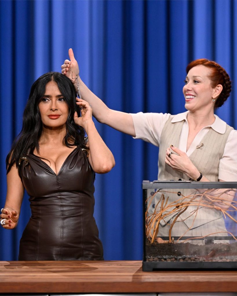 Salma Hayek next to a redhead lady showing off bugs