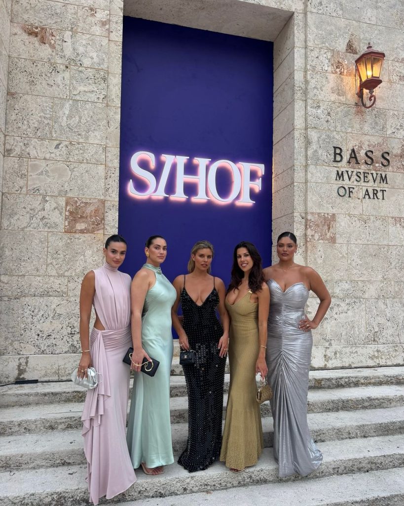 Five beautiful babes posing in front of a sign that says s/hof