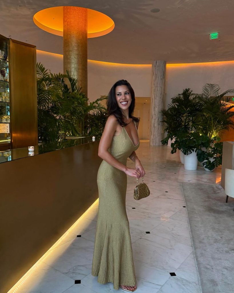 Sexy brunette in a nice dress posing at a hotel lobby