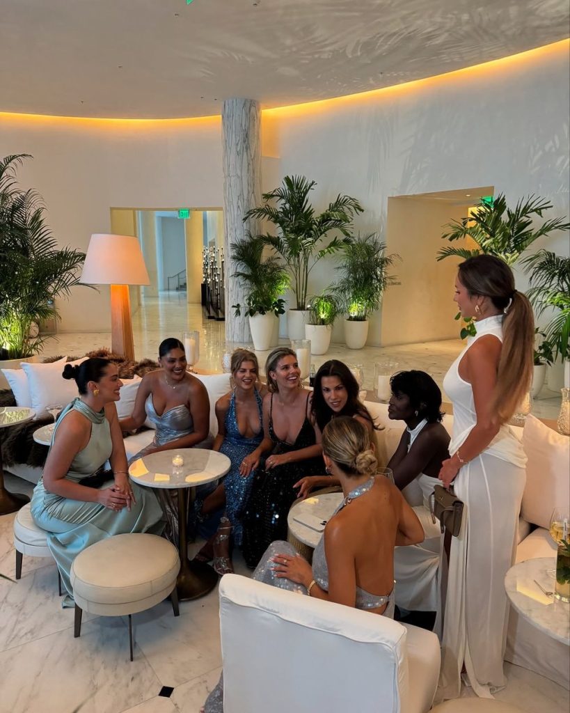 Group of beautiful women sitting down on a hotel sofa together wearing beautiful dresses