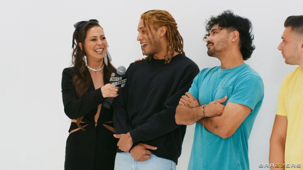 Porn star host Cherie DeVille laughs while interviewing a male contestant for a game show