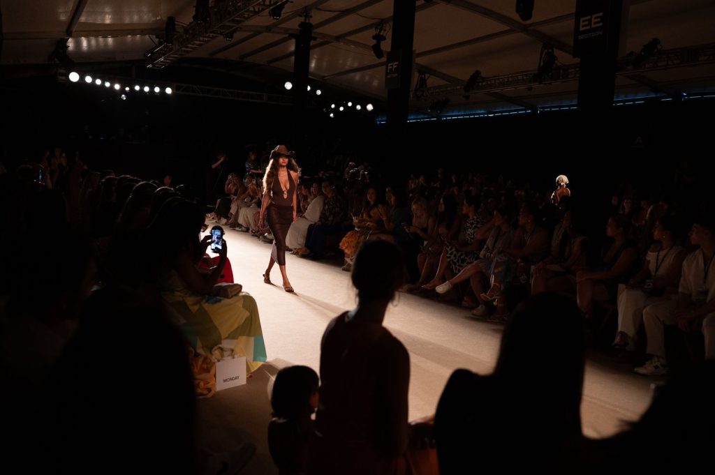 Audience watching a model walk the runway in a swimsuit