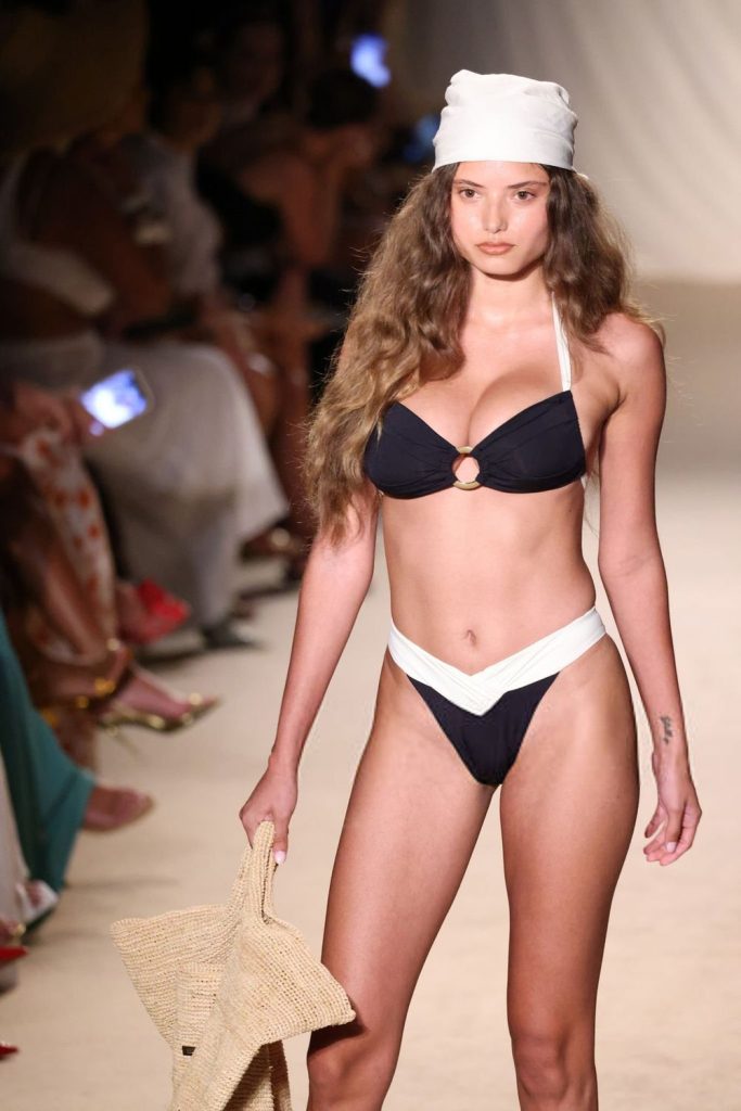 Swimsuit model with big boobs strikes a pose on the runway