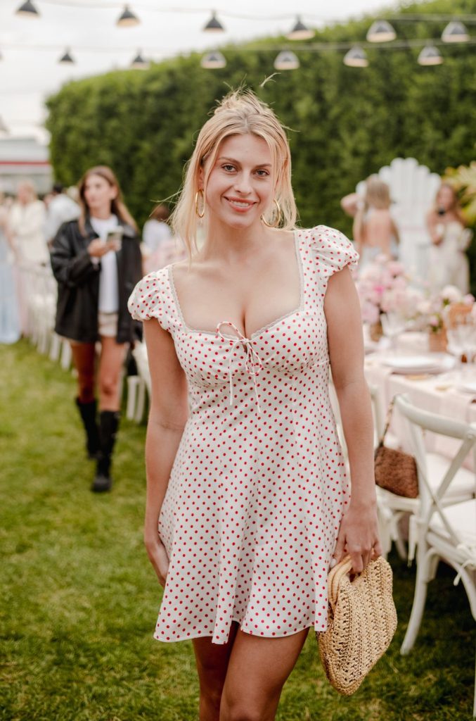 Big tit blonde showing cleavage in a pretty dress at an outdoors event on the grass