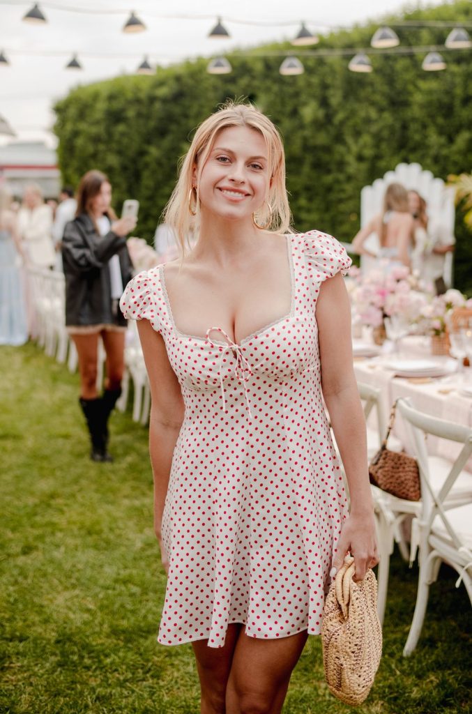 Pretty blonde smiles while wearing a sun dress at an outdoor event