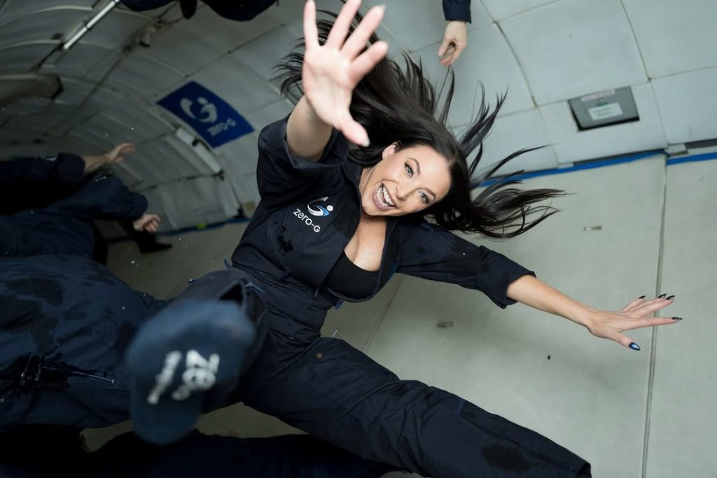 Angela White with her arms spread out in zero gravity