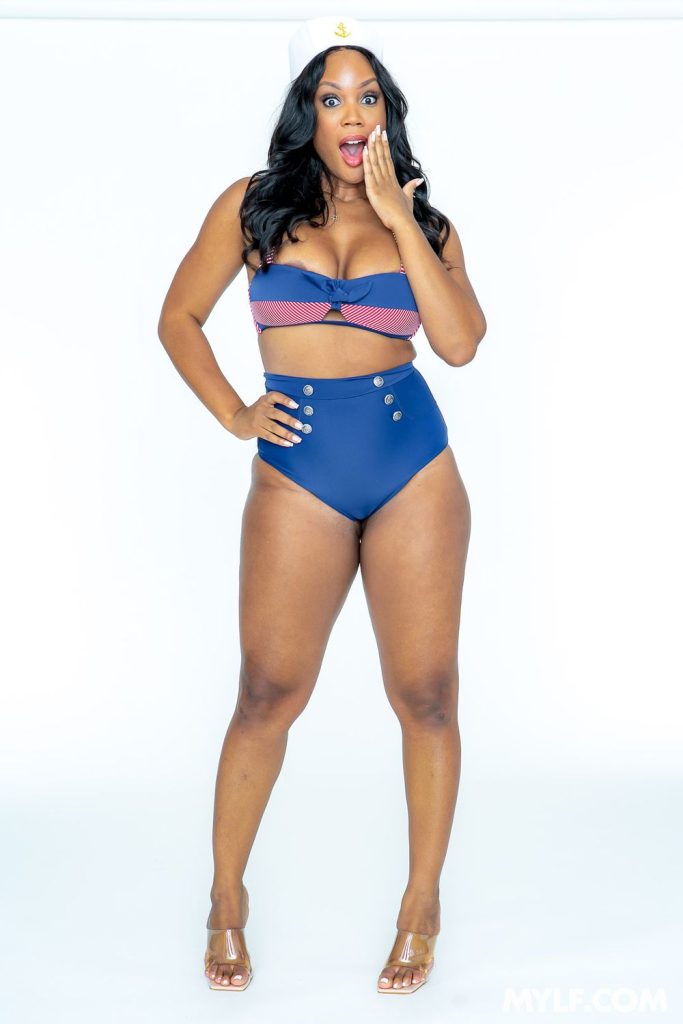 Curvy ebony woman in a sexy sailor costume makes a shocked face