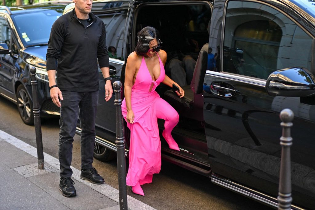 Kim Kardashian stepping out of a car in a pink outfit
