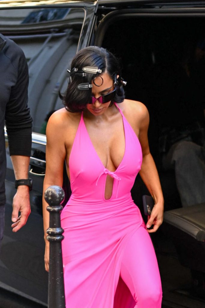 Kim Kardashian cleavage in a pink outfit while she steps out of a car