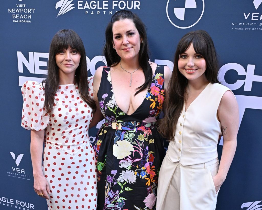 Three brunette actresses posing for the cameras on the red carpet