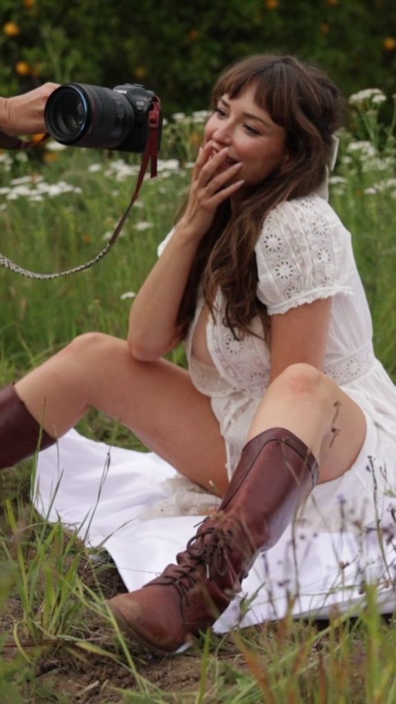 Milana Vayntrub sitting down on a blanket in the grass for a photo shoot