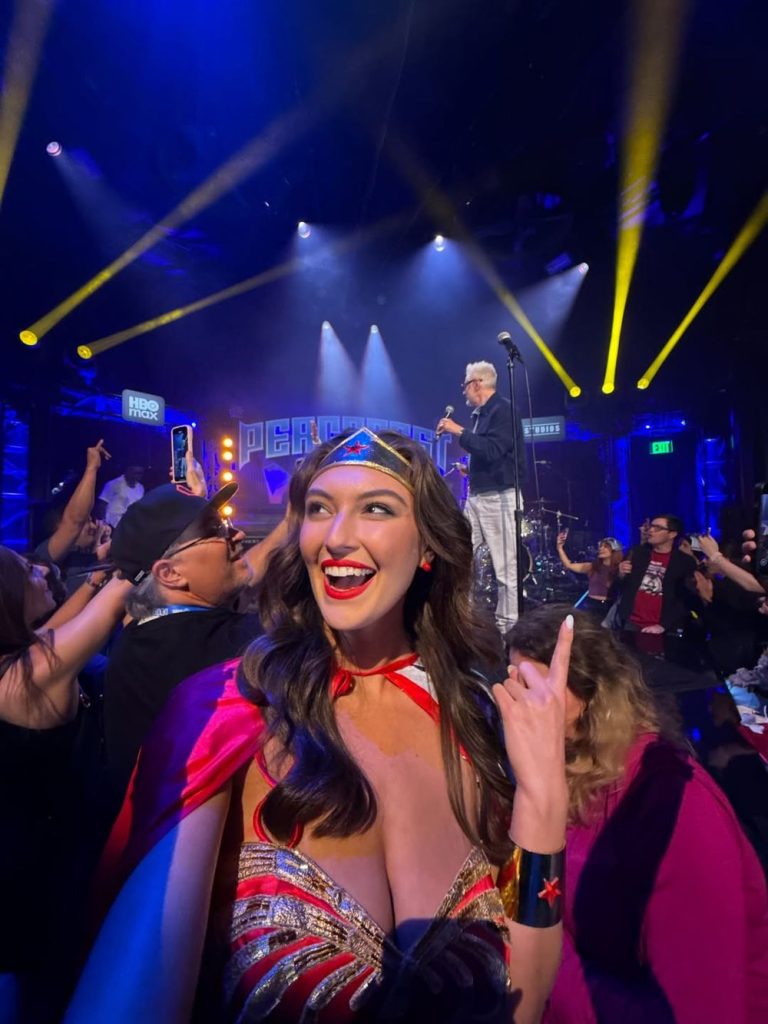Rachel Pizzolato as Wonder Woman snap a selfie in front of a stage with James Gunn on it