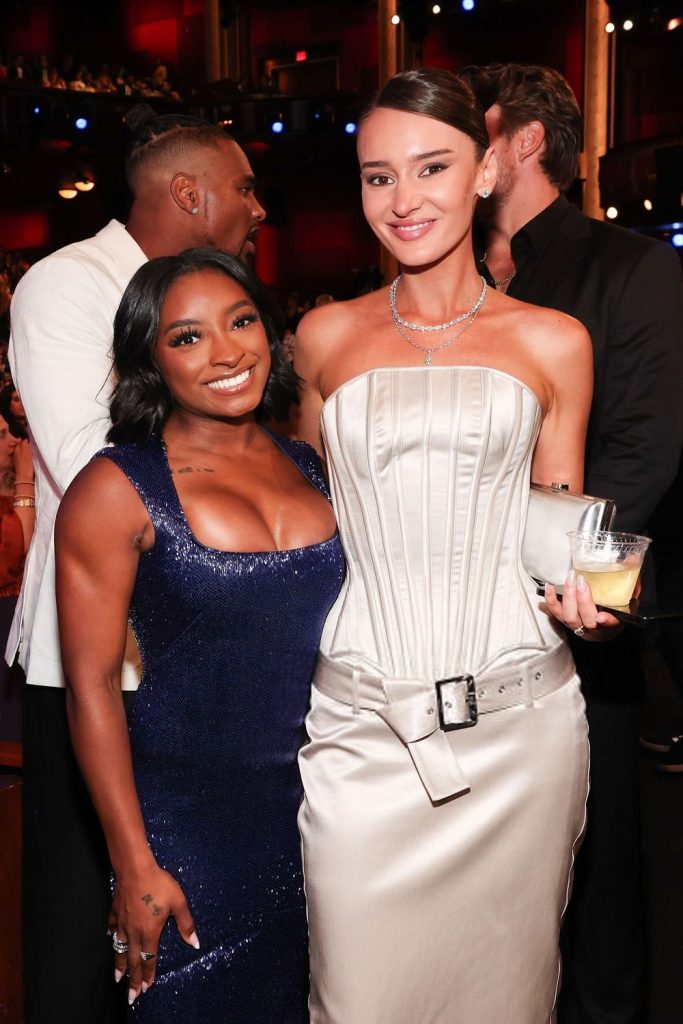 Simone Biles posing with another woman at an awards show