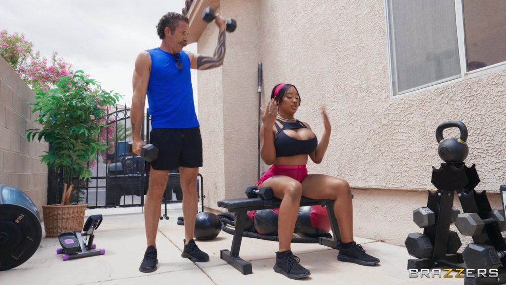 Big tit ebony babe lifting weights on a bench while a man is checking her out
