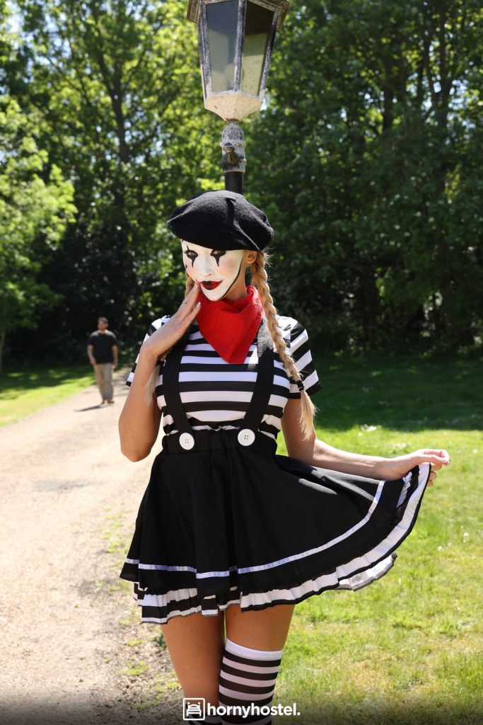 Pretty blonde mime posing in a mime outfit in the park