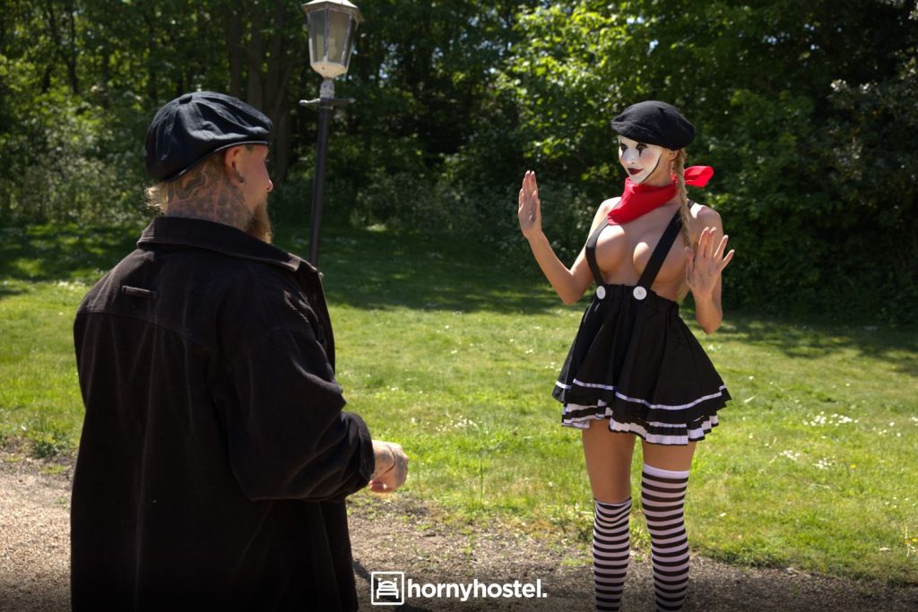 Blonde mime girl wearing just suspenders over her tits while performing in the park