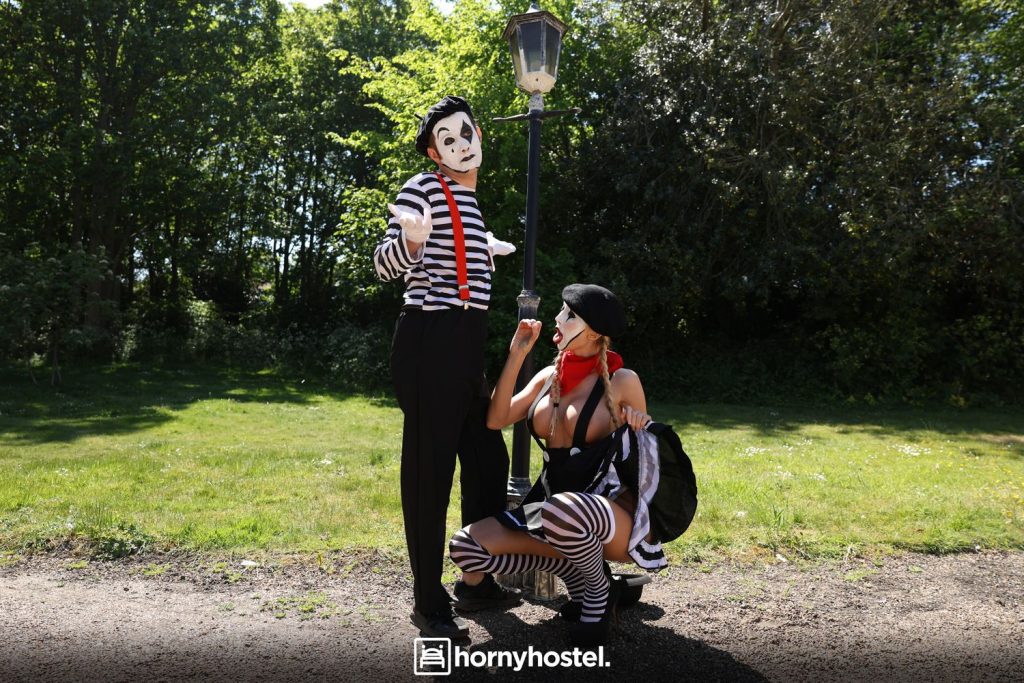 Topless blonde mime simulates a blowjob to a male mime in the park