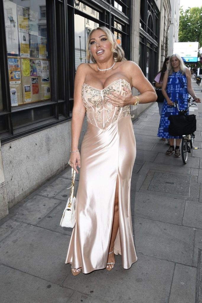 Busty blonde adjusts her boobs while arriving to an event in a fancy dress