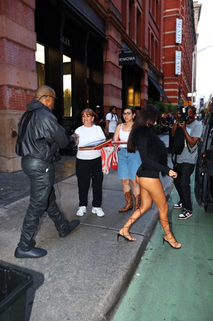 Bianca Censori legs and ass in a sexy outfit while stepping off a sidewalk with Kanye West in NYC