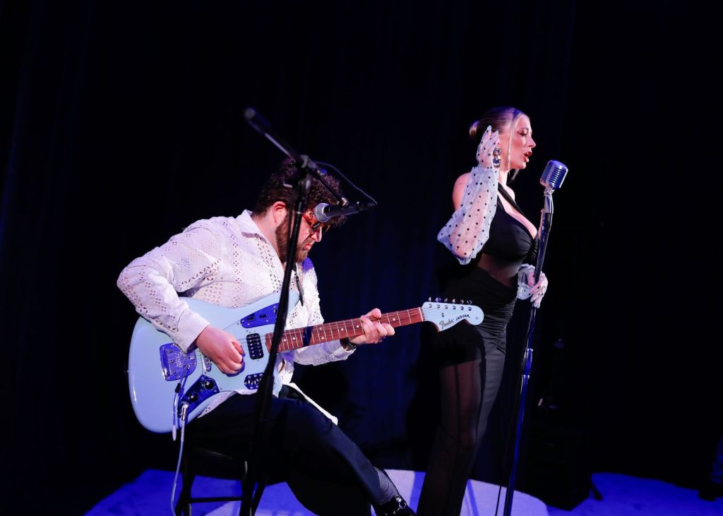 Beautiful blonde singer performs on stage with moody blue lighting