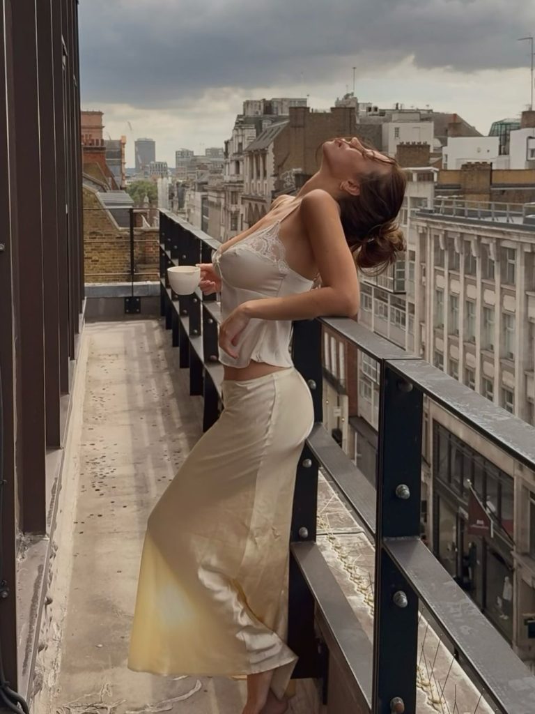 Sexy babe showing off her body while standing on a balcony