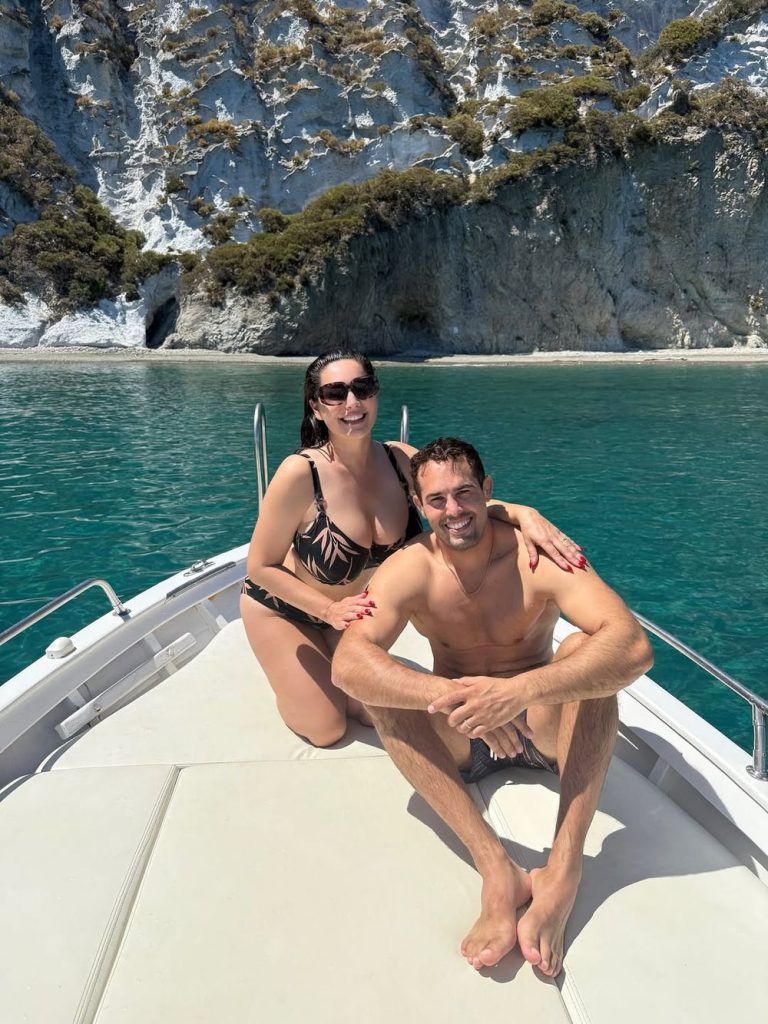 Beautiful couple in swimwear sitting at the front of a boat