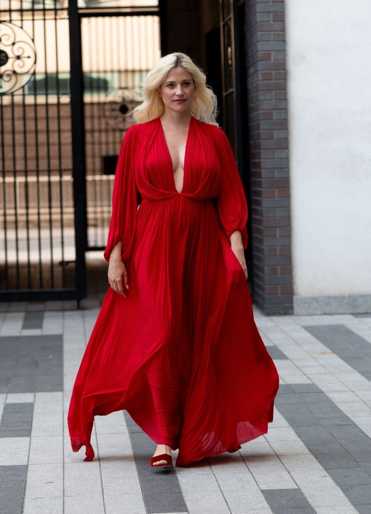 Blonde woman showing very nice cleavage while on the move in a beautiful red dress
