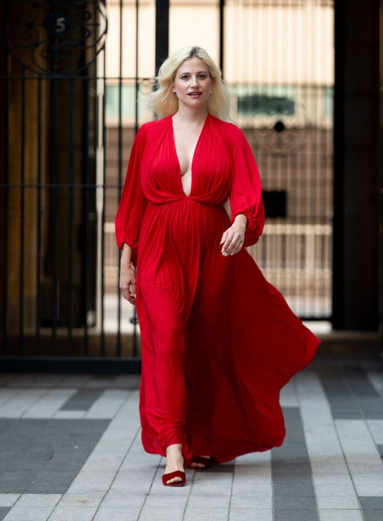 Blonde woman showing very nice cleavage while on the move in a beautiful red dress