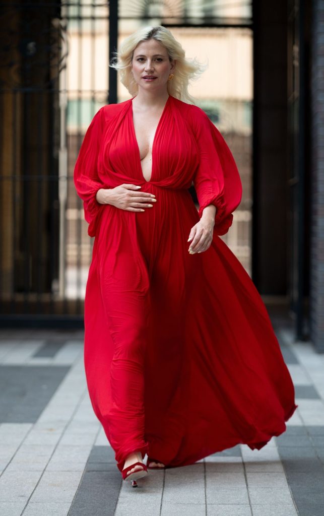 Blonde woman showing very nice cleavage while on the move in a beautiful red dress