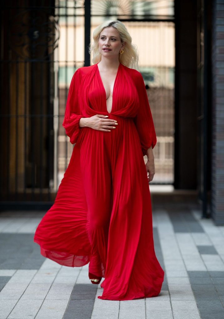 Blonde woman showing very nice cleavage while on the move in a beautiful red dress