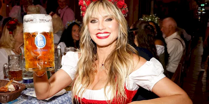 Heidi Klum toasting with a big glass of beer