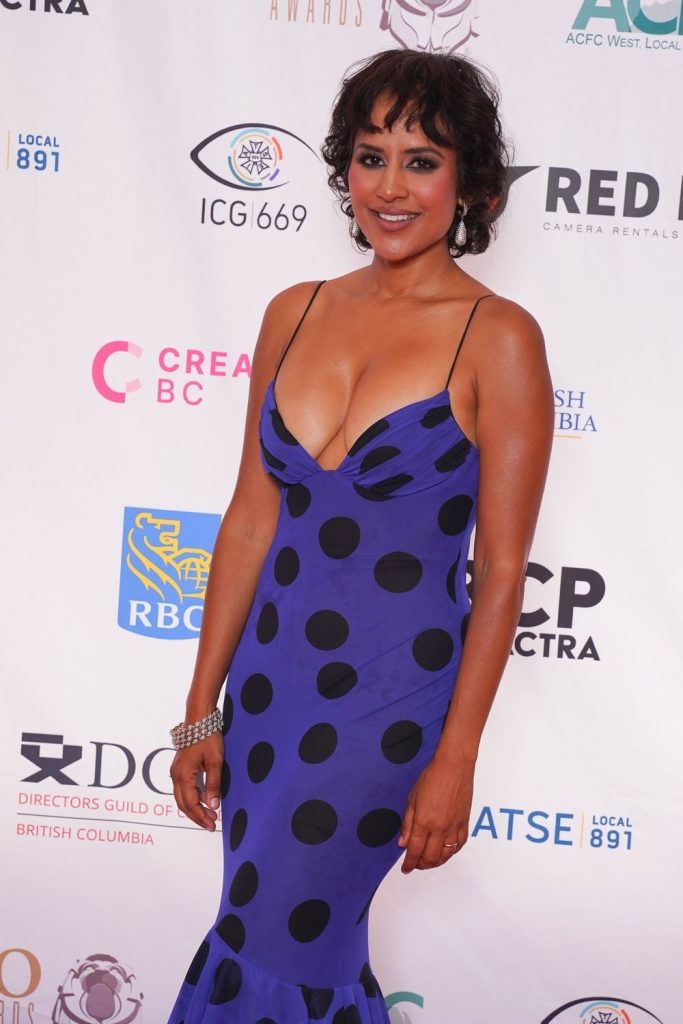Close up of Agam Darshi cleavage in a blue dress on a red carpet