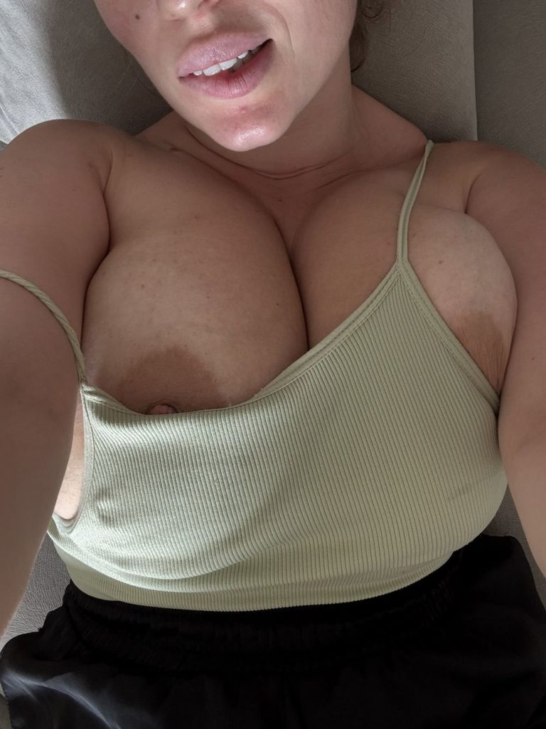 Big boob babe on her back and with her boobs falling more out of her top