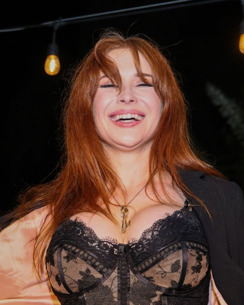 Close up of Renee Olstead laughing in a corset top