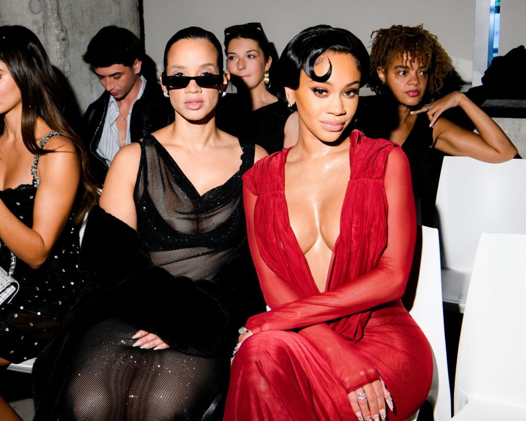 Closer view of Saweetie and the sexy woman at a fashion show