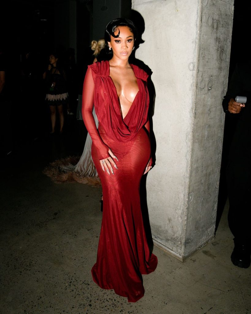 Saweetie posing next to a concrete pillar