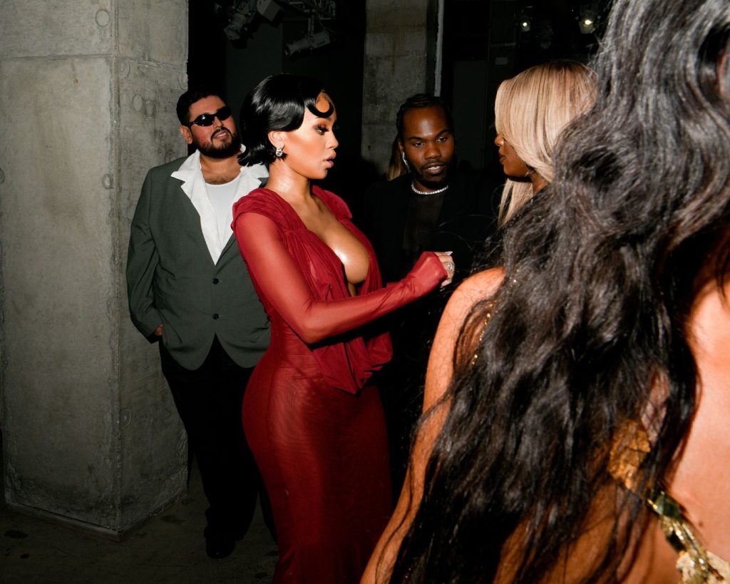Saweetie showing sideboob while greeting another woman at an event