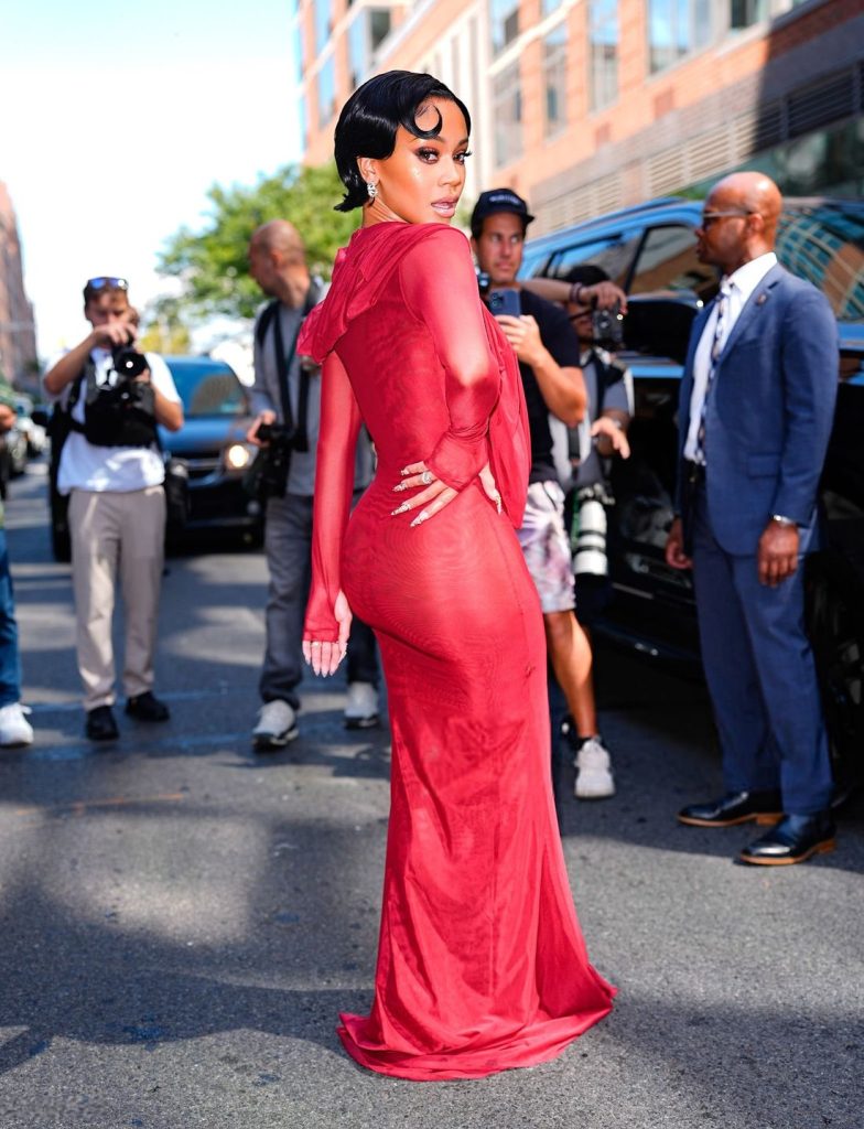 Saweetie showcasing her butt in a red dress while arriving to an event