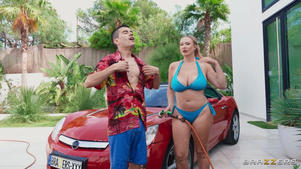 Sophie Reade spraying a car with water while a man rips open his shirt next to her
