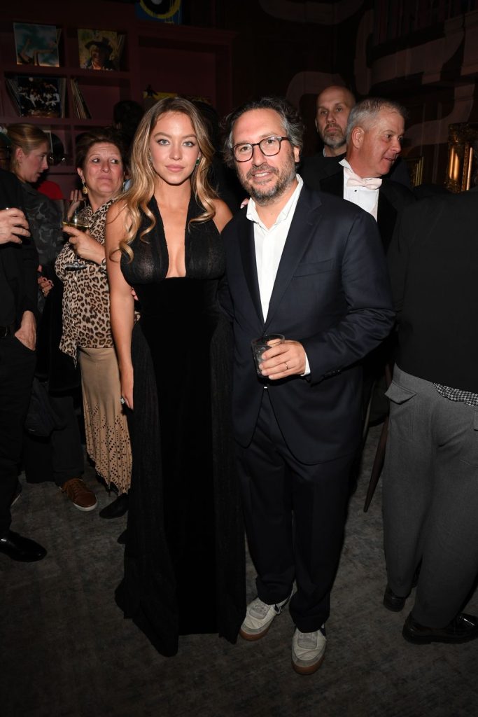 Sydney Sweeney posing with a man at the same party