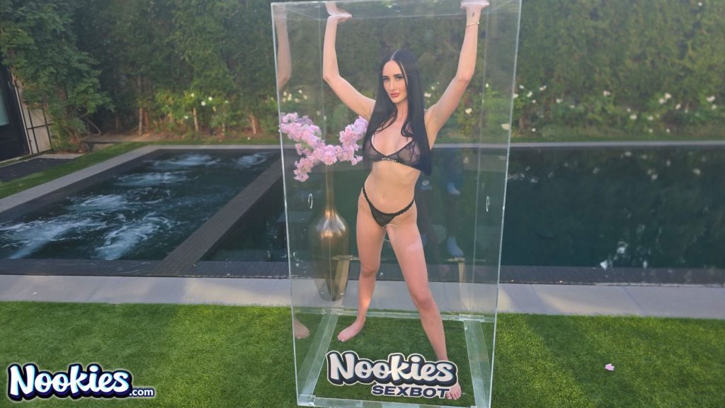 Sexbot Violet Voss in a bikini and with her arms raised inside a glass box