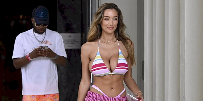 Close up view of woman with big breasts walking in a bikini top