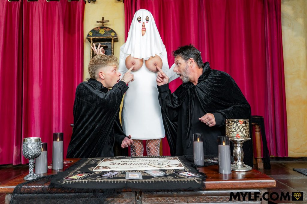 Topless ghost woman stands between two men pointing at her bare breasts