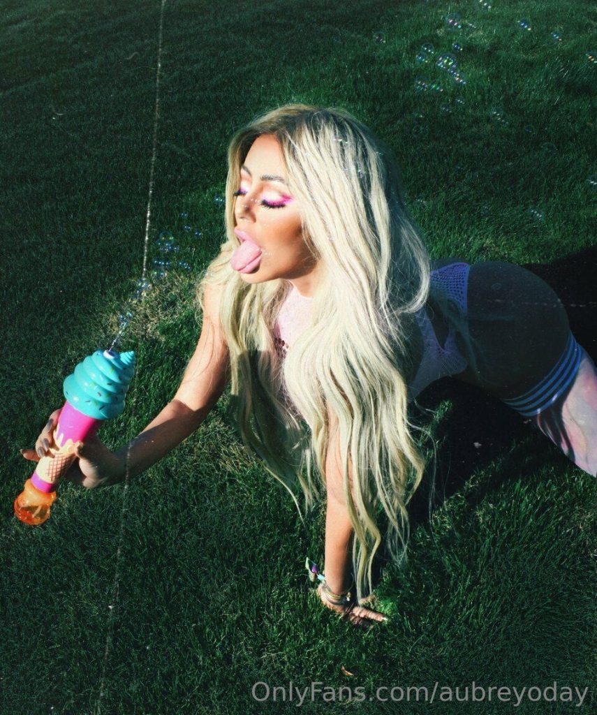 Aubrey O'Day sticking her tongue out while shooting bubbles