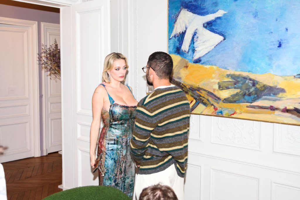 Caroline Vreeland looking busty in a nice dress while chatting with a man at a party